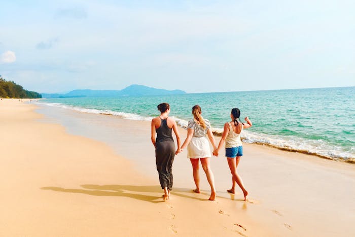 Tres amigas caminan en la playa